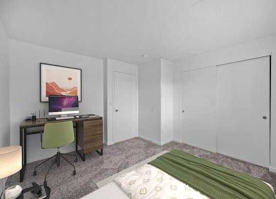 A bedroom with a bed, desk, and chair.