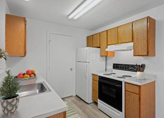 A kitchen with wooden cabinets and a white refrigerator.