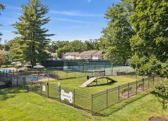 A black fence surrounds a green lawn with a sign that says Book Park.
