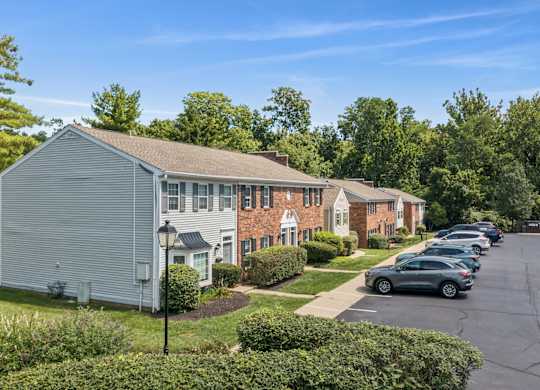 A row of houses with cars parked in front.