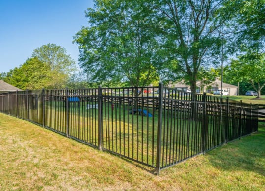 a wrought iron fence in front of a yard with a playground at Traditions at Slate Ridge, Reynoldsburg Ohio