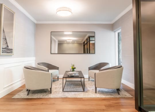 a living room with chairs and a coffee table and a mirror at Indian Creek Apartments*, Cincinnati, OH