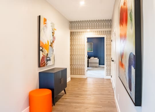 a hallway with white walls and a colorful painting on the wall