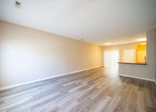 an empty living room with wood floors and white walls at Traditions at Slate Ridge, Reynoldsburg
