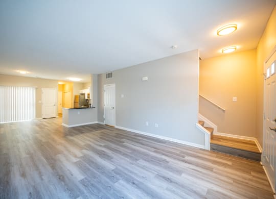 a living room with a hard wood floor and a staircase at Traditions at Slate Ridge, Reynoldsburg, OH