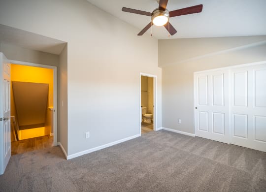 an empty living room with a ceiling fan and a door to a bathroom at Traditions at Slate Ridge, Ohio