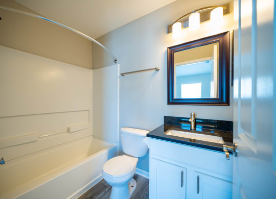 a bathroom with a toilet sink and tub and a mirror at Traditions at Slate Ridge, Reynoldsburg