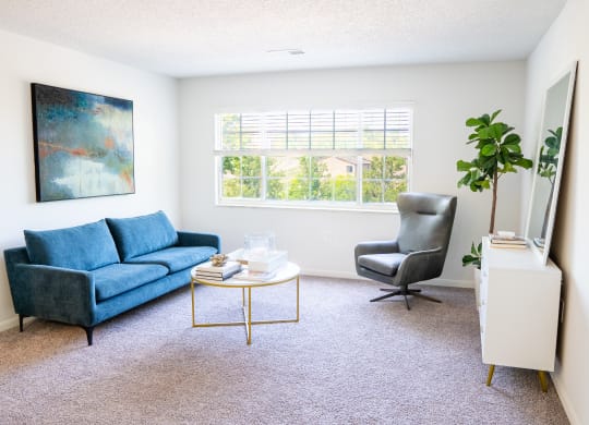 a living room with a blue couch and a blue chair