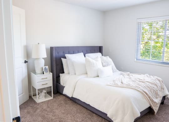 a bedroom with a bed and a nightstand with a lamp