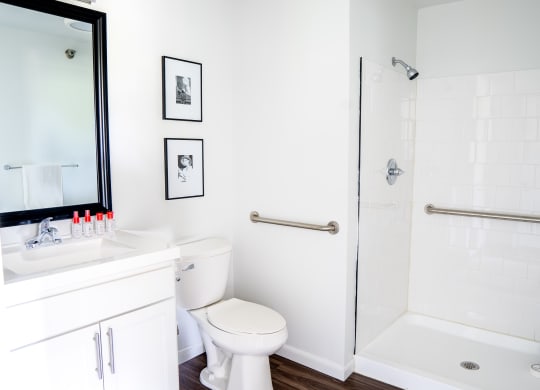 a bathroom with white walls and a white toilet next to a white bathtub