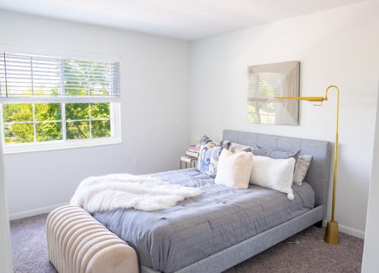 a bedroom with a bed and a lamp