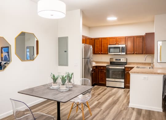a dining area with a wooden table and chairs and a kitchen with stainless steel appliances  at Waterstone Landing, Perrysburg, Ohio