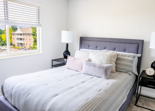 a bedroom with a large bed and two nightstands with lamps on them