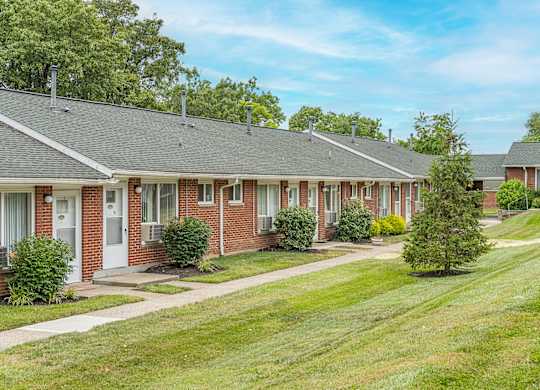 A row of houses with green lawns in front.