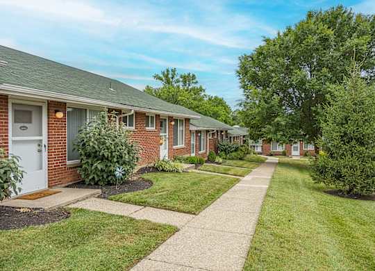 A row of houses with a sidewalk in front.