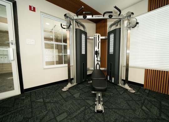 Gym with weights and a chair in the corner of a room at Honey Creek, Greenwood