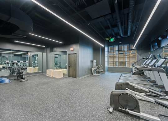 A gym with treadmills, weights, and exercise equipment at Sky Central Apartments, Cincinnati, OH