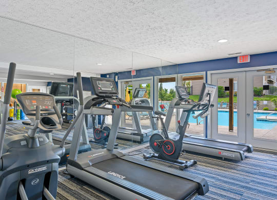 a gym with cardio machines and a pool in the background at Enclave, Beavercreek, OH, 45431