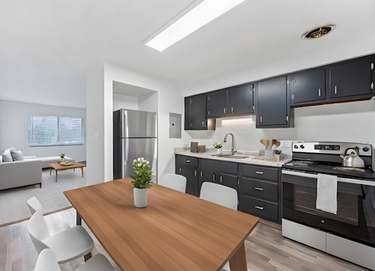 a kitchen and dining room with black cabinets and a wooden table
