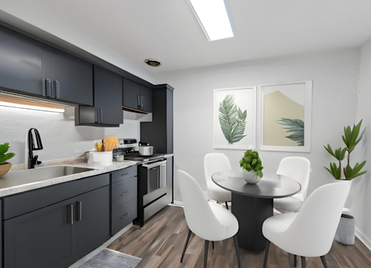 a kitchen with black cabinets and a table and chairs