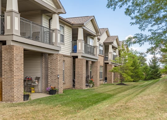 a row of apartments with balconies and grass and trees at Four Bridges, Liberty Township