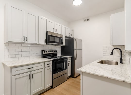 a kitchen with white cabinets and stainless steel appliances
