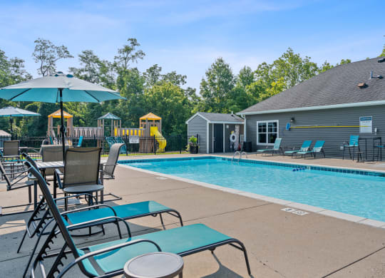 Resort style swimming pool is next to our house with chairs and an umbrella at Galbraith Pointe Apartments and Townhomes*, Ohio
