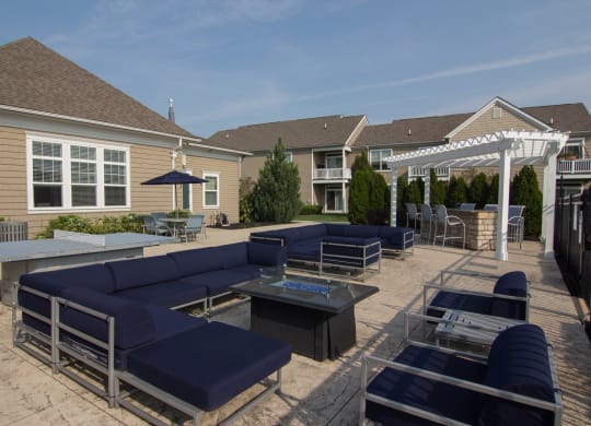 an outdoor patio with blue couches and chairs and a white pergola  at Grove City Summit, Grove City, OH, 43123