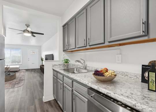 A kitchen with a marble countertop and a bowl of fruit on it.