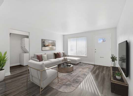 A living room with a white couch, a coffee table, and a television.