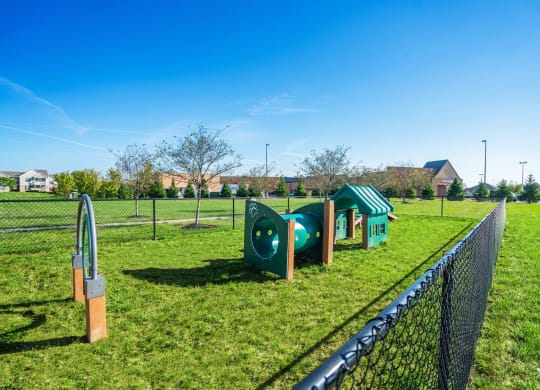a park with green playground equipment and a fence at Grove City Summit Apartments, Grove City, OH