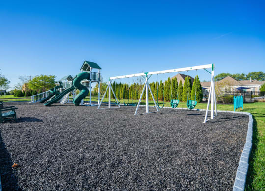 a playground with a slide and swings in a park at Grove City Summit Apartments, Grove City, OH, 43123