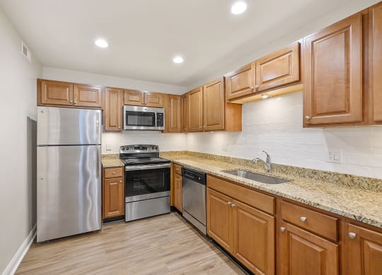 a kitchen with wooden cabinets and stainless steel appliances at Harpers Point Apartments, Cincinnati, OH, 45249