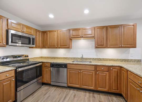 a kitchen with wooden cabinets and granite countertops at Harpers Point Apartments, Cincinnati, OH, 45249