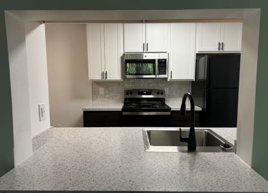 Kitchen with white cabinets and black appliances and a sink  at Hilltop Apartments, Cincinnati, Ohio, 45213-2638