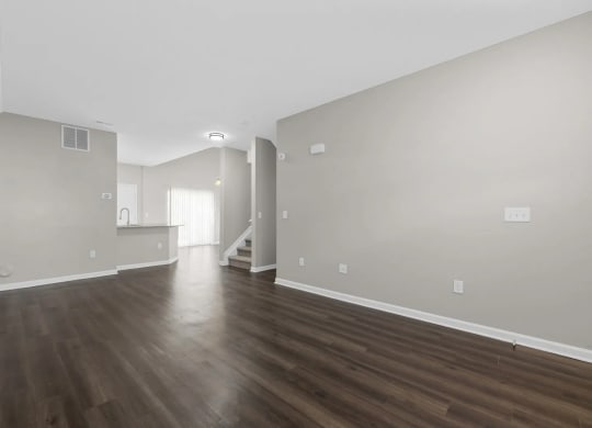 the living room and dining room of an empty house with wood floors at Traditions at Slate Ridge, Reynoldsburg, 43068