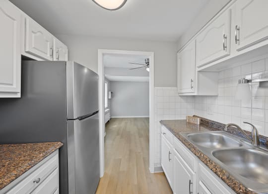a kitchen with stainless steel appliances and white cabinets at Huntley Ridge, Kettering