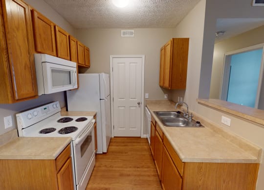 a kitchen with wooden cabinets and white appliances and a sink