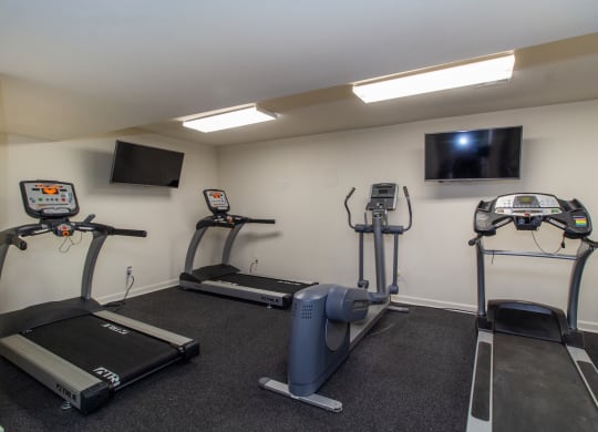 two exercise machines and a tv in a gym room at Rivers Edge Apartments and Townhomes, Dayton, OH, 45405