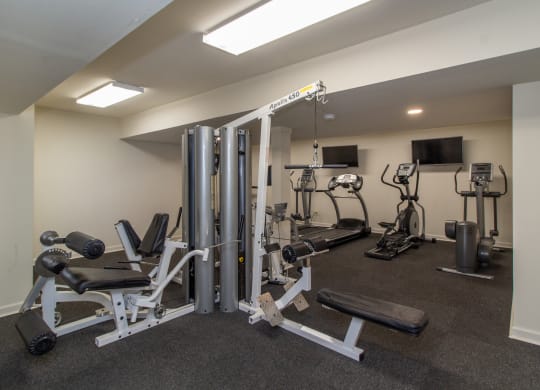 a gym with weights and cardio equipment on the floor and a tv at Rivers Edge Apartments and Townhomes, Ohio, 45405