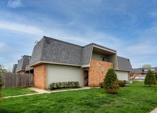 a house with a gray roof and a yard with green grass at Rivers Edge Apartments and Townhomes, Dayton, Ohio