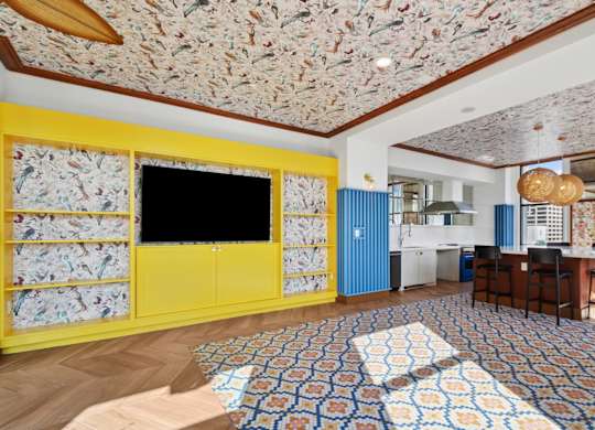 A room with a patterned ceiling and a yellow cabinet.