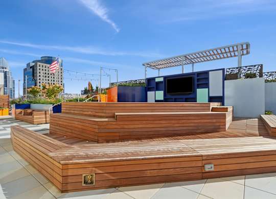 A wooden deck with a TV on top and a city skyline in the background.