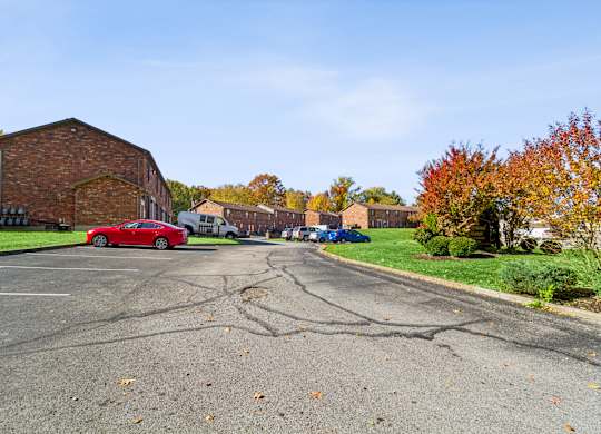 A red car is parked on the left side of a street.