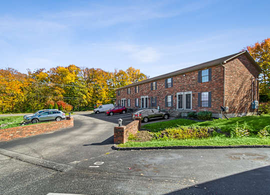 A red brick house with a driveway in front.