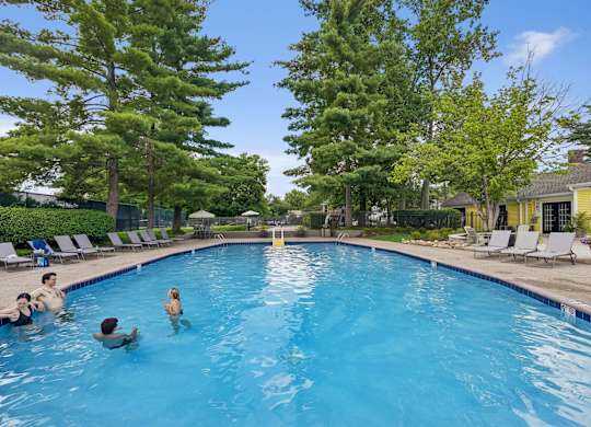 A group of people are swimming in a blue pool.