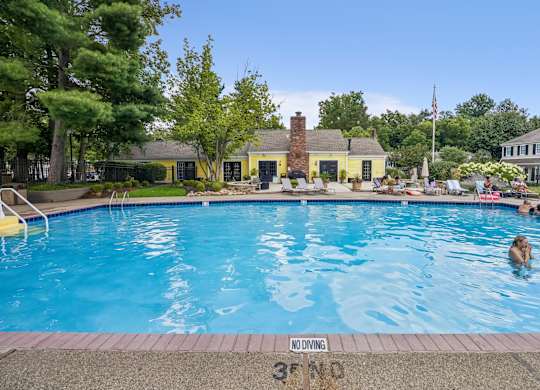 A swimming pool with people in it and a sign that says
