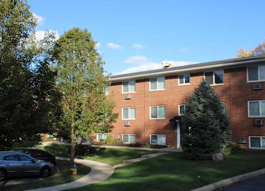 A red brick building with a tree in front of it.