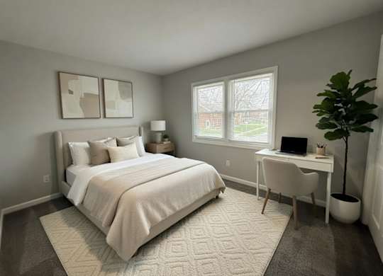 A bedroom with a bed, desk, and chair.