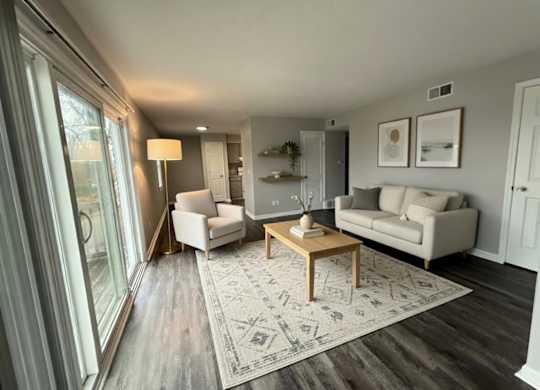 A living room with a grey carpet and a wooden coffee table.